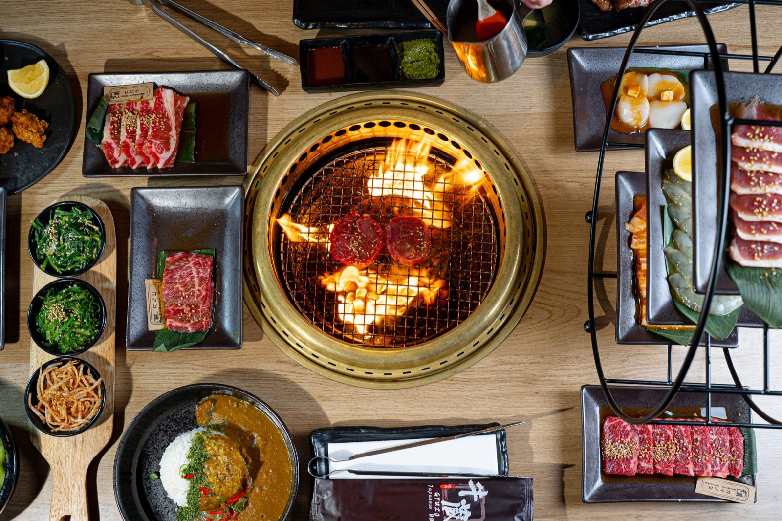 Cortes de Wagyu, guarniciones y una parrilla de mesa encendida en Gyuzo BBQ en Rockville