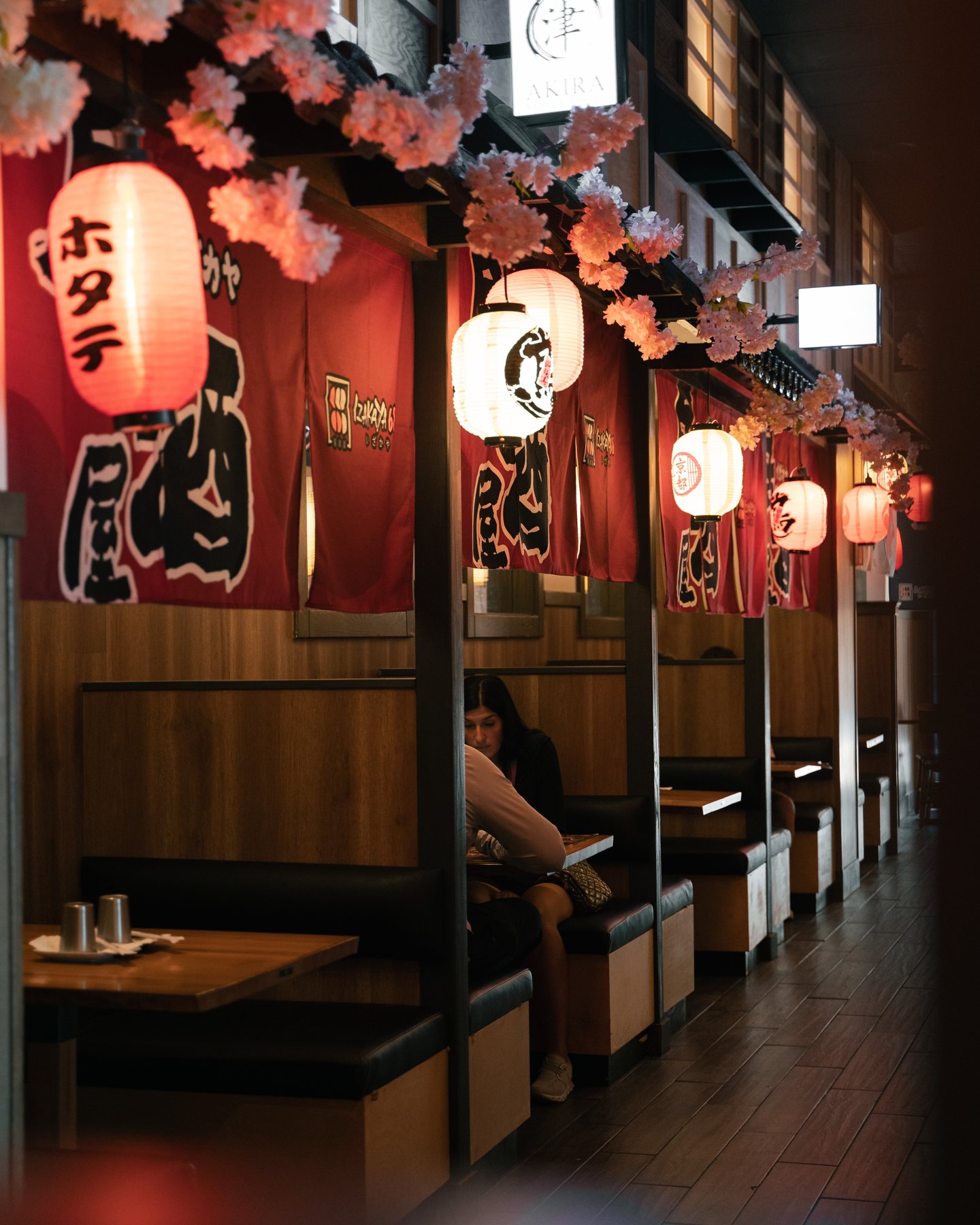 Reservados iluminados con faroles bajo cortinas noren rojas en Izakaya 68, en Hunt Valley, MD