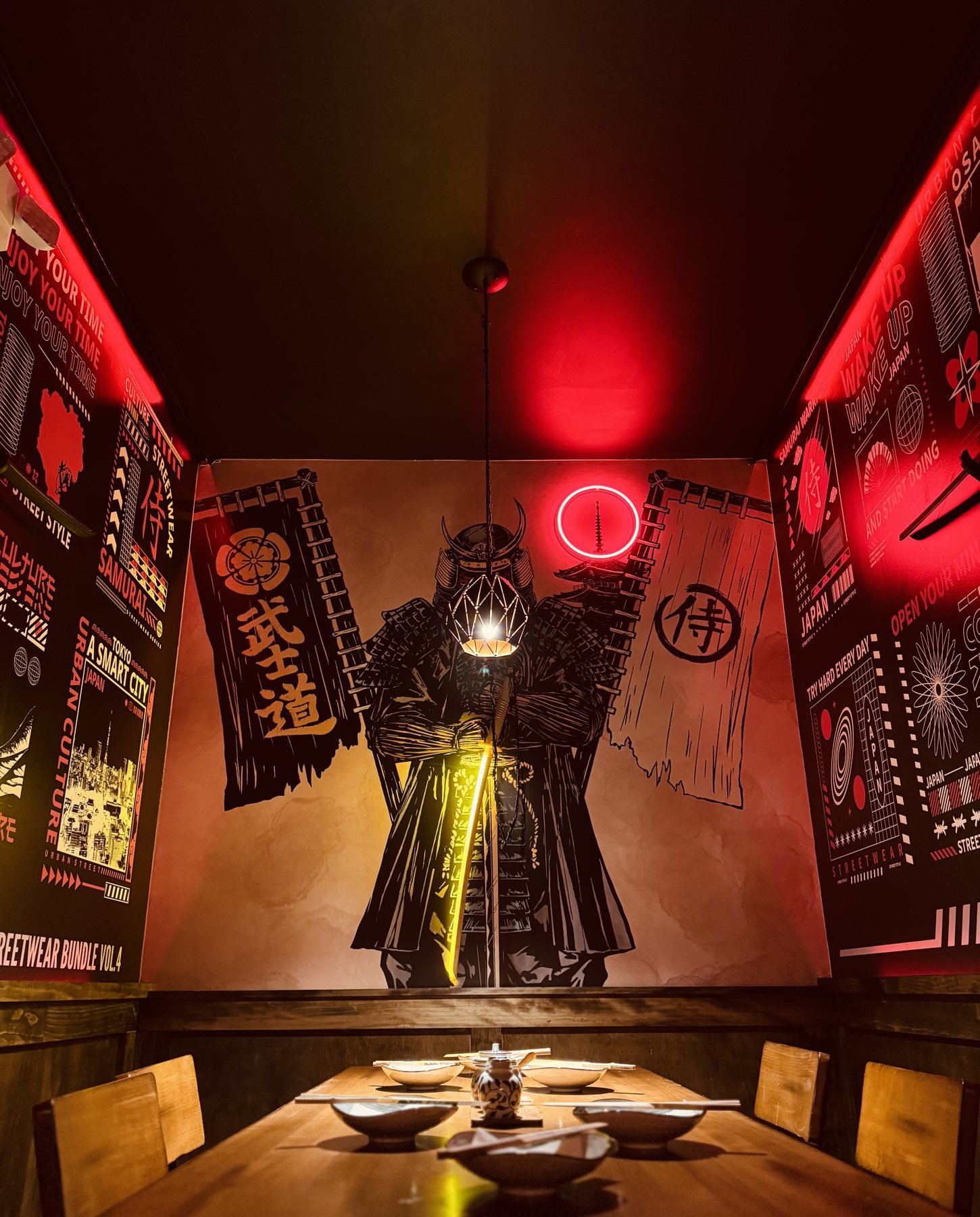 La Samurai Room de Izakaya Nana, con una armadura samurái en exhibición bajo neón rojo