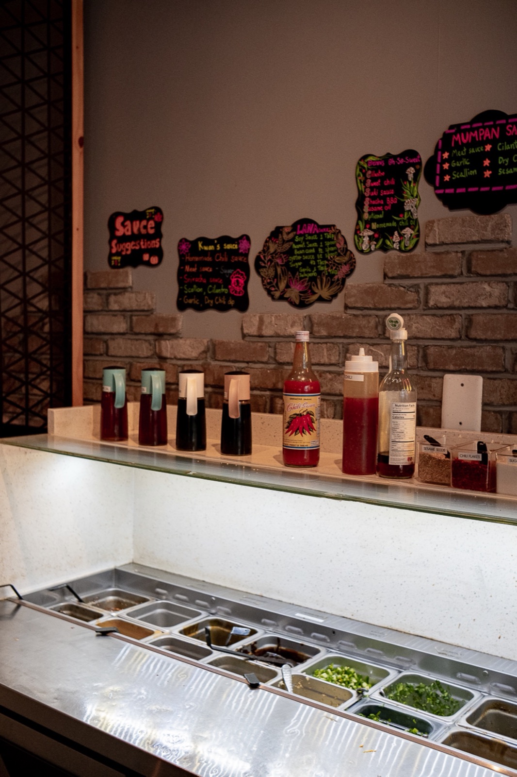 Urban Hot Pot 的自助酱料台,摆着酱料瓶和一格格切好的香草与调料