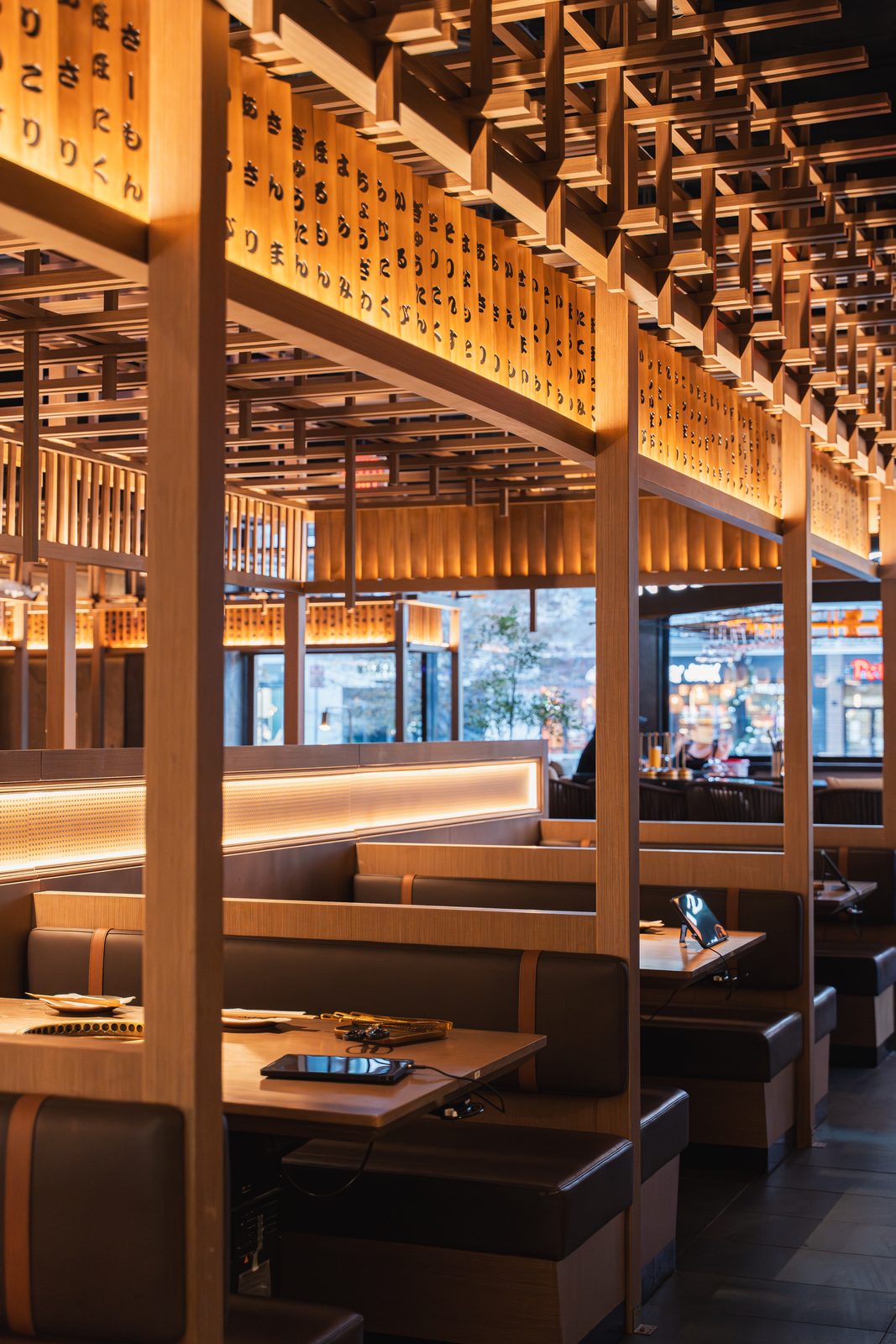 Paper lanterns and warm wood screens over the grill booths at Gyu San Columbia