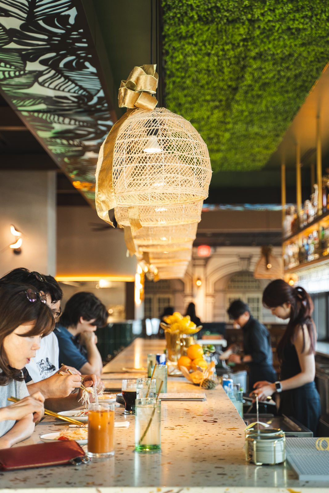 Woven rattan lanterns and a green moss ceiling over the bar at Southeast Impression in Fairfax