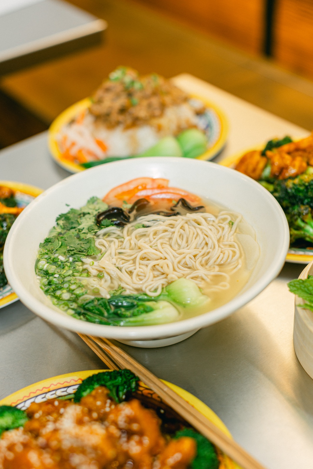Hand-pulled noodle soup with greens, wood ear mushroom and tomato on a Wasai table
